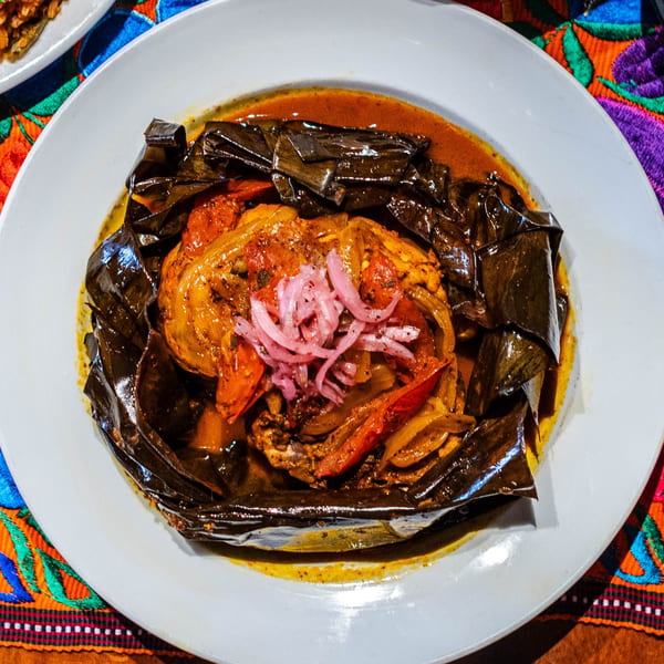 Picos Restaurant's Mexican dish, a chicken tamale in banana leaves, topped with pickled red onions.